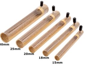 Five clear glass test tubes with cork stoppers containing brown sand, arranged by increasing length from 15mm to 30mm (labels visible).